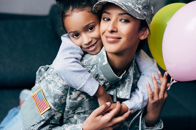 Military Woman Lifted Girl having Balloon in her Hand